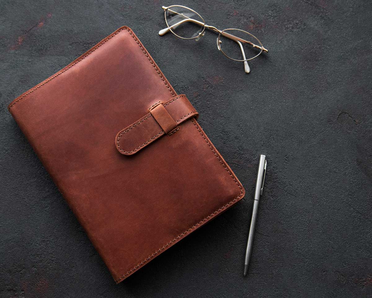 leather notebook glasses and pen
